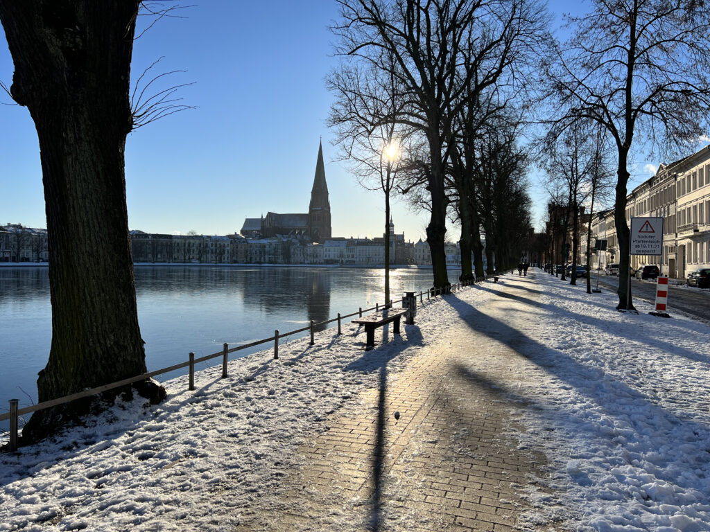 Schnee auf dem Weg und Eis auf dem Pfaffenteich bei strahlend blauem Himmel und Sonnenschein an Weihnachten